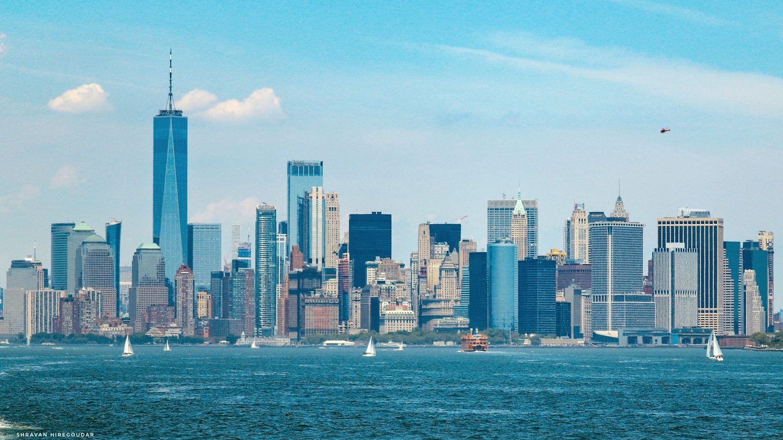 a view of a city skyline with sailboats in the water