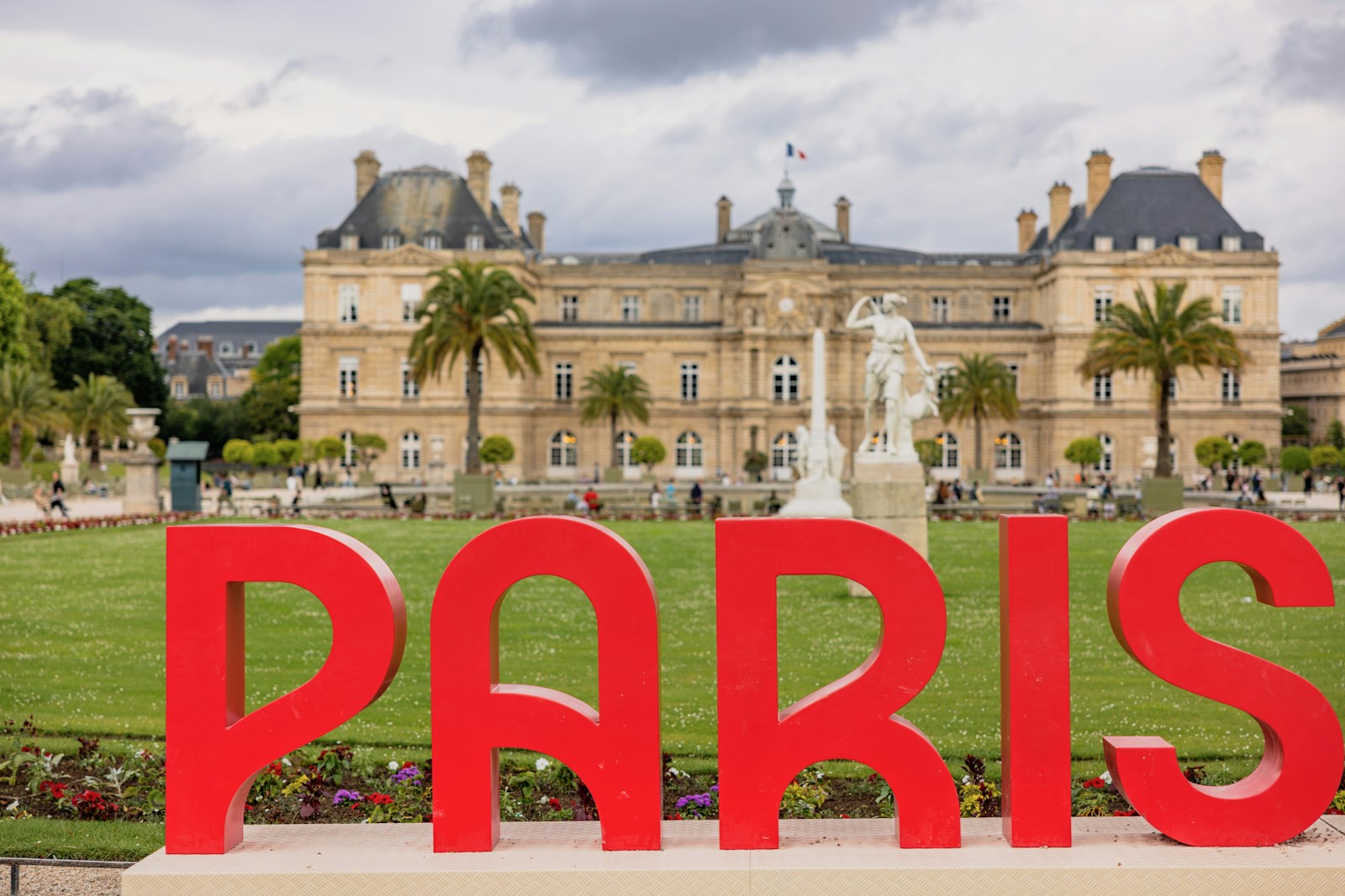 A large red sign that says paris in front of a building