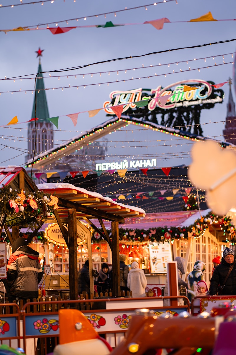 Festive christmas market with illuminated stalls and towers.