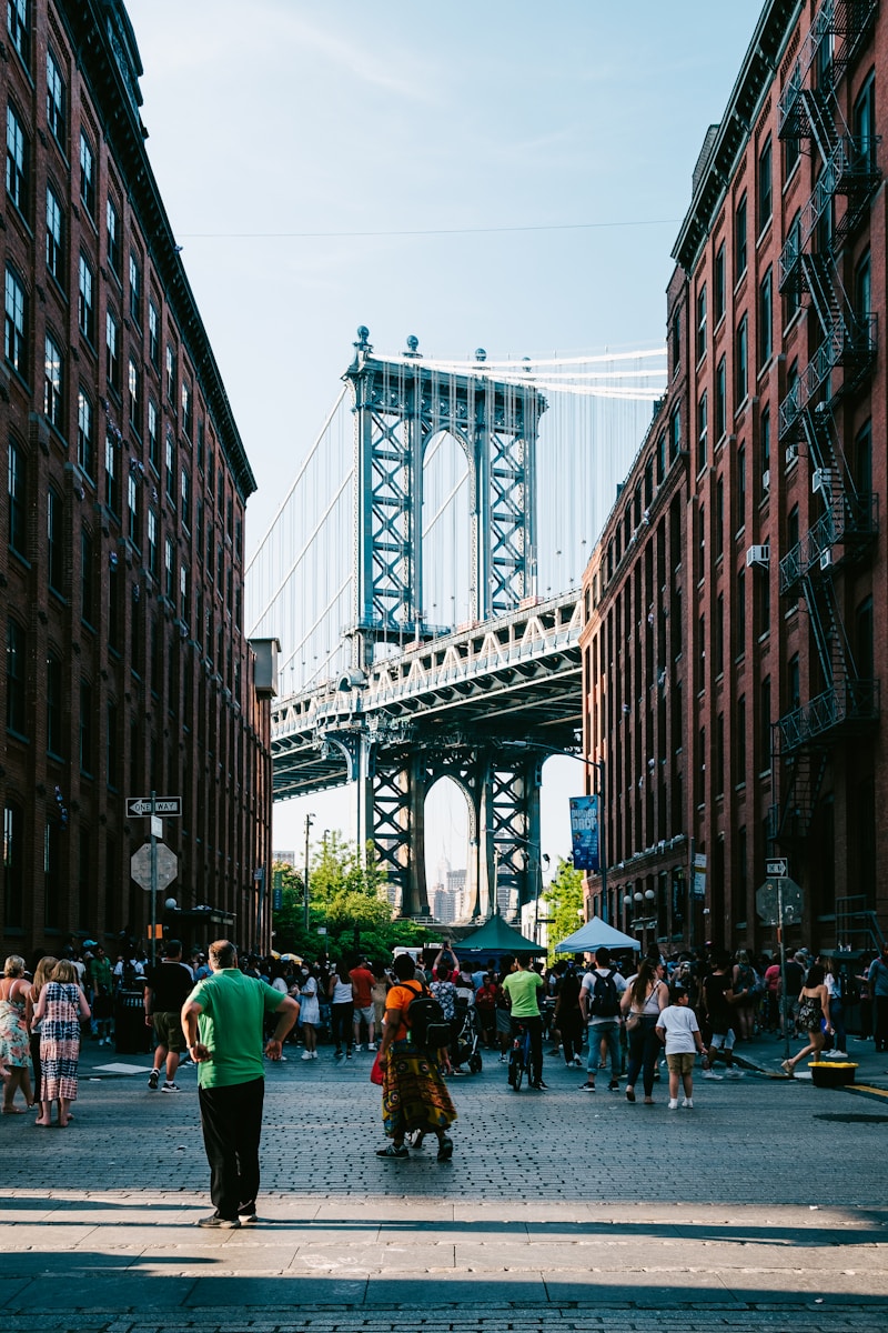 a group of people walking down a street next to tall buildings