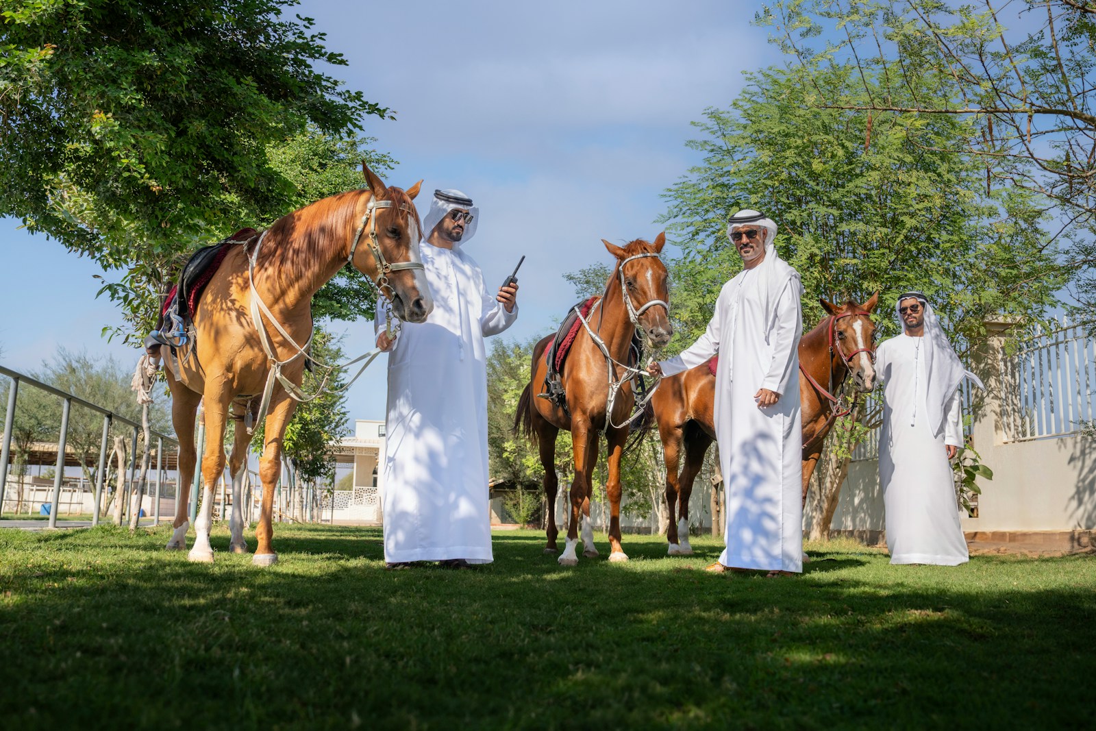 A group of men standing next to horses