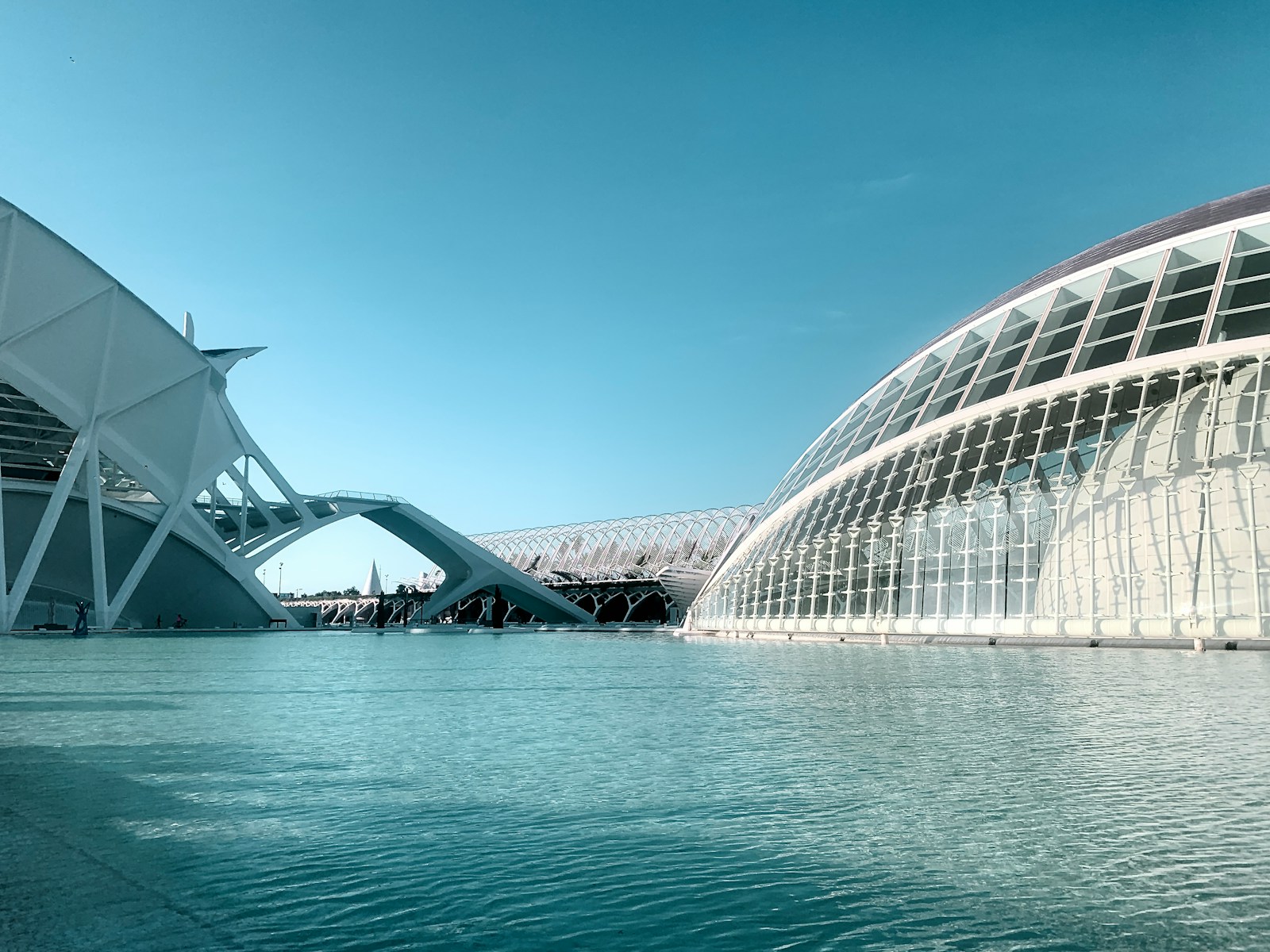Modern architecture reflected in a calm blue water body.